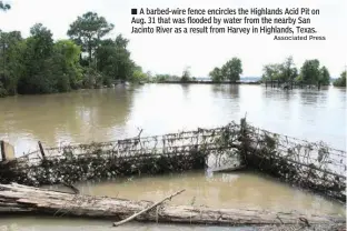  ?? Associated Press ?? n A barbed-wire fence encircles the Highlands Acid Pit on Aug. 31 that was flooded by water from the nearby San Jacinto River as a result from Harvey in Highlands, Texas.