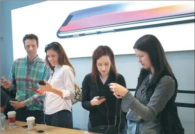  ?? GETTY IMAGES ?? Customers check out the Apple iPhone X after it went on sale at a store in Manhattan, New York, on Nov 3.