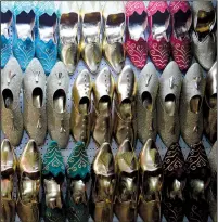  ??  ?? Elaborate wedding shoes decorate the store of Zied Khdrhaoui in the medina of Tunis in Tunisia.