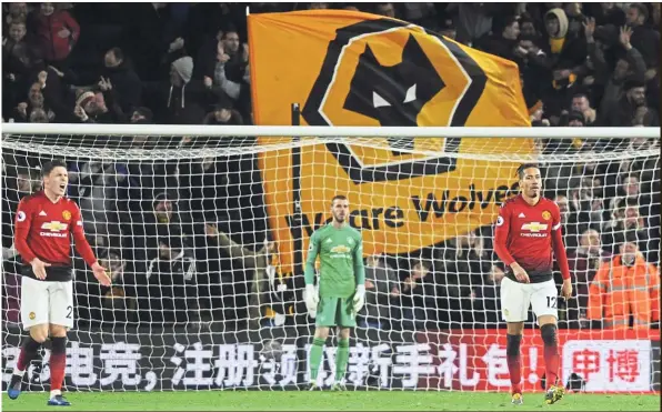  ?? — AP ?? Bad moon rising: (from left) Manchester United’s Victor Lindelof, goalkeeper David de Gea and Chris Smalling react after Smalling scored an own goal in the English Premier League match against Wolves at the Molineux Stadium on Tuesday. United lost 2-1.