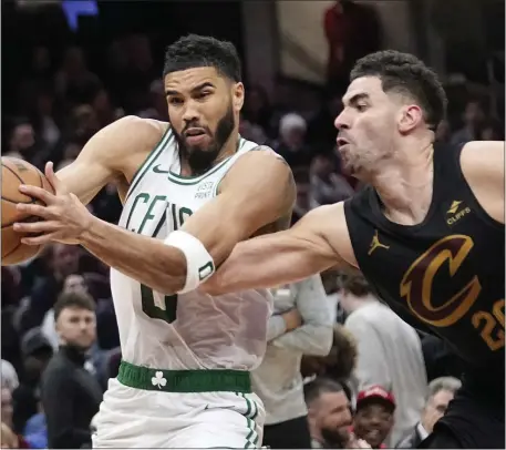  ?? SUE OGROCKI — THE ASSOCIATED PRESS ?? Boston Celtics forward Jayson Tatum, left, drives past Cleveland Cavaliers forward Georges Niang in the second half of an NBA game Tuesday in Cleveland. The Celtics had their 11-game win streak snapped.