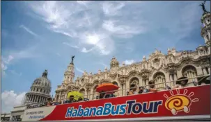  ?? The Associated Press ?? CAPITOL BUILDING: Tourists ride a tour bus June 17 in front of the Capitolio in Havana, Cuba. Five of 12 private bed-and-breakfast owners in Havana and Cuba’s southern colonial city of Trinidad told The Associated Press that they received cancellati­ons...