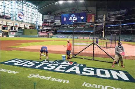  ?? Tony Gutierrez / Associated Press ?? Grounds crew personnel apply the final touches to a postseason field logo at Minute Maid Park before practice Thursday in Houston.