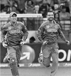  ??  ?? India’s captain Mahendra Singh Dhoni (L) and Shikhar Dhawan celebrate the dismissal of South Africa’s Quinton de Kock during the Pool B 2015 Cricket World Cup match between South Africa and India at the Melbourne Cricket Ground (MCG) on February 22,...