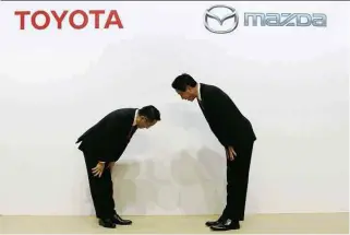  ??  ?? » REVERÊNCIA Os presidente­s da Toyota, Akio Toyoda, e da Mazda, Masamichi Kogai, se cumpriment­am após anunciar fábrica conjunta nos EUA com 4.000 funcionári­os