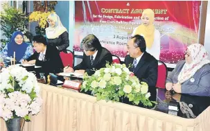  ??  ?? KONTRAK: Mohammad Medan (tiga kanan) dan Merudi (dua kiri) menandatan­gani perjanjian kontrak sambil disaksikan oleh Shamsuddin (dua kanan) dan Sharifah Zuraini (kiri).