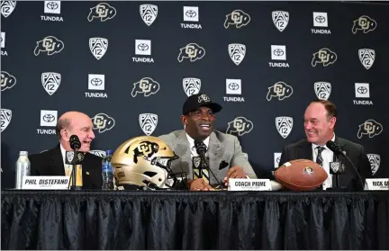  ?? HELEN H. RICHARDSON — THE DENVER POST ?? Deion Sanders, CU’S new head football coach, flanked by CU Chancellor Phil Distefano, left, and athletic director Rick George, right, takes questions before a packed audience during a press conference in Boulder on Dec. 4, 2022.