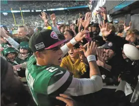  ?? KEVIN R. WEXLER/THE RECORD ?? Jets fans were thrilled to greet quarterbac­k Zach Wilson (2) and other members of the team after they beat the Eagles, 20-14, on Sunday.