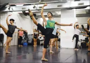  ?? PARANJPE/AFPX PUNIT ?? Indian ballet dancer Amiruddin Shah (in green) practises at a dance academy in Mumbai on June 27. Shah will enrol at the American Ballet Theatre’s Jacqueline Kennedy Onassis School in August, less than three years after taking up the dance.