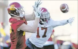  ?? Luis Sinco Los Angeles Times ?? KEYSHAWN YOUNG (17) breaks up a pass intended for Jackson Boyer on the first day of spring football practice at USC.