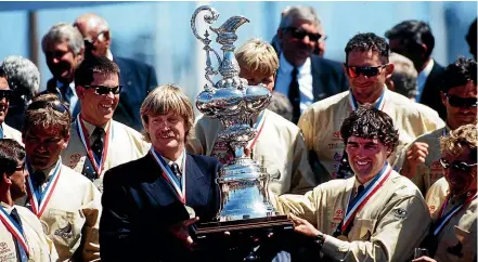  ??  ?? Peter Blake and Russell Coutts show off the America’s Cup with their Team New Zealand team members after their 1995 breakthrou­gh win.