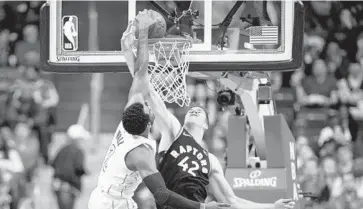  ?? NICK WASS/ASSOCIATED PRESS ?? Wizards guard John Wall dunks over Raptors center Jakob Poeltl in the first half. Wall finished with 27 points and 14 assists for Washington, which tied the series after climbing back from a 14-point deficit in the second half.