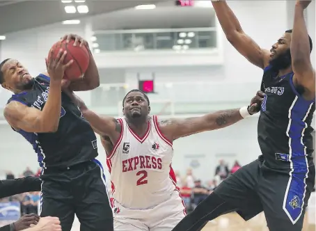  ?? PHOTOS: DAN JANISSE ?? DeAndre Thomas, centre, of the Windsor Express, tries to impede the scoring attempt of Ed Horton of the Kitchener-Waterloo Titans during Game 1 in the Central Division semifinal Friday at the Atlas Tube Centre in Lakeshore.