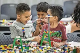  ?? RICARDO B. BRAZZIELL / AMERICAN-STATESMAN 2015 ?? Alexander Saldana, 5, laughs out loud as Makayo Haywood-Guerrero and his twin brother, Max Haywood-Guerrero, 6, play with Legos during Lego Lab at the Carver Branch of the Austin Public Library.