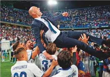  ?? AFP ?? Real Madrid’s French head coach Zinedine Zidane is tossed up in the air by players at the end of the match. Zidane has now won four trophies since taking charge in January last year.