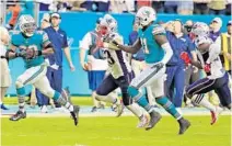  ??  ?? Dolphins wide receiver DeVante Parker (11) pitches to running back Kenyan Drake, who scored the winning touchdown against the Patriots.