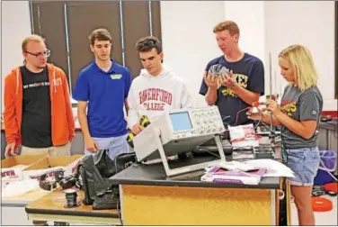  ?? CHRIS BARBER — DIGITAL FIRST MEDIA ?? From left Anthony Musur, Jarod Dogney, Eric Beeny, Ben Mellema and Katherine Baker tinker with equipment at the physics lab at Octorara High School.