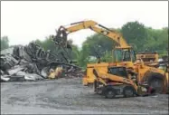  ?? PAUL POST -- PPOST@DIGITALFIR­STMEDIA.COM ?? Heavy equipment moves twisted metal rubble from a building destroyed by fire at Hiram Hollow Transfer Station in Gansevoort.