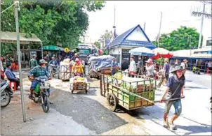  ?? HENG CHIVOAN ?? A Cambodian cargo hauler pulls his heavily laden cart past the Poipet Internatio­nal Border Checkpoint in Banteay Meanchey province in 2019.