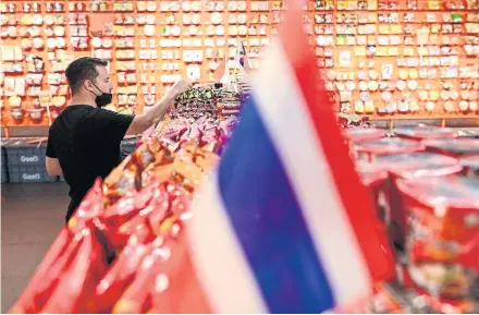  ?? AFP ?? A man looks at instant noodles at a Bangkok shop in August. Where are Thai consumers getting the money to finance their consumptio­n?