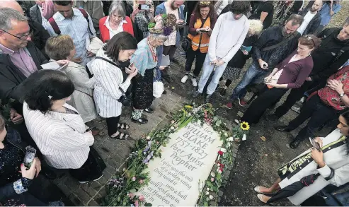  ?? VICTORIA JONES / PA VIA THE ASSOCIATED PRESS ?? People gather around a newly unveiled headstone for English poet William Blake at Bunhill Fields in London after it is unveiled on Sunday. Blake had been buried in an unmarked common grave in the borough of Islington.