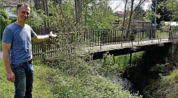  ??  ?? Petrirodas Bürgermeis­ter Marcel Schönau zeigt die marode Brücke über den Flößgraben, die durch eine Stahlbrück­e ersetzt werden soll. Fotos: Claudia Klinger ()