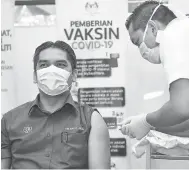  ?? — Gambar Bernama ?? VAKSIN: Dr Radzi menerima suntikan vaksin COVID-19 jenis Pfizer BioNTech oleh vaksinator Muhammad Bakhrul Ulum Mohd Rashid di Pejabat Kesihatan Putrajaya, Presint 11 semalam.