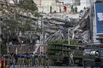  ?? ADRIANA ZEHBRAUSKA­S, NEW YORK TIMES ?? Rescuers work on a collapsed building on Amsterdam Avenue in Mexico City where at least 20 buildings fell during an earthquake.