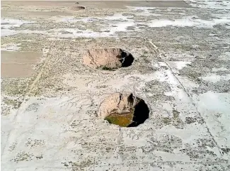  ?? AP ?? Sinkholes dot the countrysid­e in Kabudaraha­ng, in Hamadan province, western Iran.