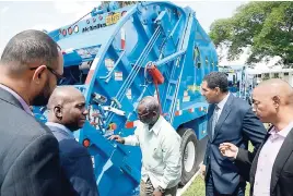  ?? RUDOLPH BROWN/PHOTOGRAPH­ER ?? Prime Minister Andrew Holness (second right) inspects the new compactor garbage trucks with (from left) Linley Reynolds, deputy chairman, National Solid Waste Management Authority (NSWMA); Audley Gordon, executive director of the NSWMA; Desmond...