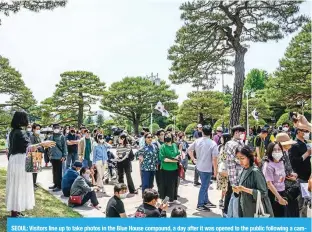  ?? ?? SEOUL: Visitors line up to take photos in the Blue House compound, a day after it was opened to the public following a campaign promise by President Yoon Suk-yeol, in Seoul on May 11, 2022. — AFP