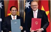  ?? AAP PHOTO VIA AP ?? IMPROVING RELATIONS
Prime Ministers Pham Minh Chinh of Vietnam (left) and Anthony Albanese of Australia pose with the documents they exchanged during a signing ceremony at Parliament House in the Australian capital Canberra on Thursday, March 7, 2024.