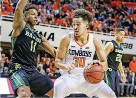  ?? [PHOTO BY DEVIN LAWRENCE WILBER, TULSA WORLD] ?? Oklahoma State forward Jeffrey Carroll tries to get around Baylor forward Mark Vital during the Bears’ 67-56 victory on Tuesday in Stillwater.