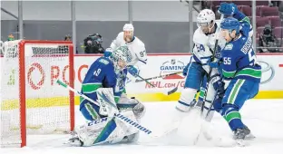  ?? BOB FRID • USA TODAY SPORTS ?? Vancouver Canucks defenceman Guillaume Brisebois, right, checks Toronto Maple Leafs forward Wayne Simmonds as Canucks goalie Braden Holtby makes a save in the first period of Sunday’s NHL game at Rogers Arena in Vancouver. It was Vancouver’s first game since March 24 due to COVID-19. Brisebois, 23, was the captain of the Charlottet­own Islanders during the 2016-17 Quebec Major Junior Hockey League season. Sunday was his first game of the season with Vancouver.