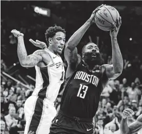  ?? Kin Man Hui / San Antonio Express-News ?? James Harden (der.) elude a DeMar DeRozan e intenta un enceste en la derrota de los Rockets el martes 3 de diciembre ante los Spurs en el AT&T Center.