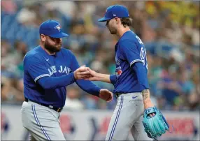  ?? ?? The Associated Press
Toronto Blue Jays relief pitcher Adam Cimber, right, hands the ball to interim manager John Schneider as he is taken out of the game against the Tampa Bay Rays.