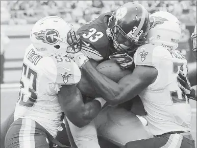  ?? Larry Roberts/Post-Gazette ?? Isaac Redman gets stacked up between Tennessee’s Moise Fokou, left, and Bernard Pollard Sunday.