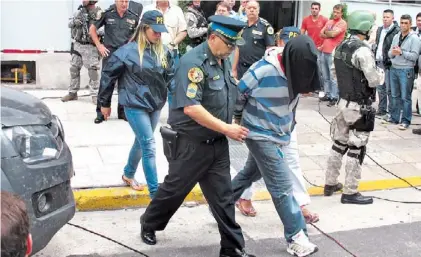  ??  ?? Marche preso. Uno de los detenidos, ayer, saliendo de la División Drogas Peligrosas de la Policía Federal.