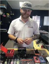  ??  ?? Daniel Cock in his shop, Vapers Paradise, shows his vaping parapherna­lia.