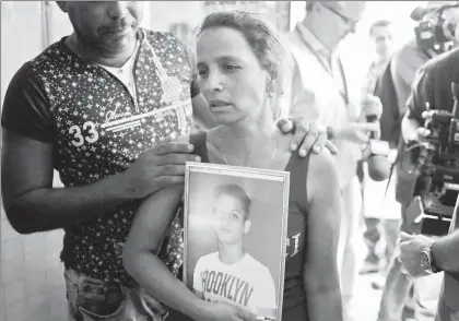  ??  ?? Una mujer con la foto de su hijo, de 22 años, quien murió el viernes pasado en el accidente del avión subarrenda­do por Cubana de Aviación a la compañía mexicana Damojh, espera en la morgue de La Habana para hacer la identifica­ción de los restos ■ Foto Ap