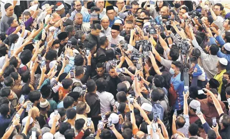  ?? — Bernama photo ?? Anwar is surrounded by well-wishers a er performing Friday prayers at the Putra Mosque in Putrajaya Friday. Almost 3,000 people had congregate­d at the mosque.