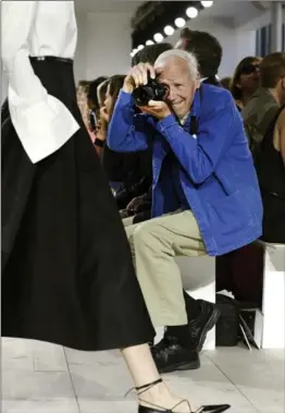  ?? RICHARD DREW, THE ASSOCIATED PRESS ?? Bill Cunningham shoots a Michael Kors show during Fashion Week in New York in 2014. Cunningham, a longtime fashion photograph­er for the New York Times known for taking pictures of everyday people on the streets of New York, has died. He was 87.