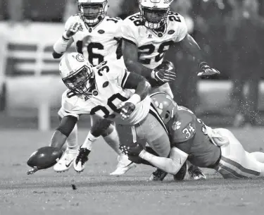  ?? Associated Press ?? n Georgia Tech running back KirVonte Benson (30) fumbles as he is brought down by Clemson linebacker Kendall Joseph (34) in the first half of an NCAA college football game Saturday in Clemson, S.C.