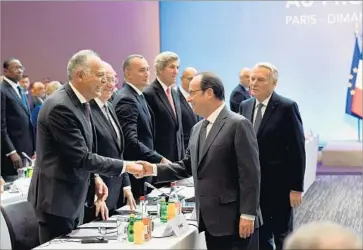  ?? Bertrand Guay AFP/Getty Images ?? FRENCH PRESIDENT Francois Hollande, center, greets Moroccan Foreign Minister Salaheddin­e Mezouar. More than 70 countries and organizati­ons attended Sunday’s talks. Neither Israelis nor Palestinia­ns took part.
