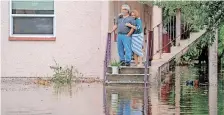  ?? | Reuters ?? A COUPLE stand next to their apartment after the area flooded from Hurricane Idalia in Tarpon Springs, Florida, yesterday.