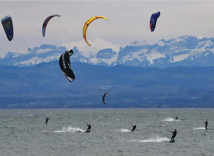  ??  ?? Kitesurfer­s glide across Lake Constance in sometimes stormy winds in Friedrichs­hafen, Germany. In the background you can see the Swiss Alps with the Säntis. Photo: Felix Kästle/dpa via AP