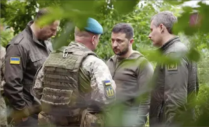  ?? Ukrainian Presidenti­al Press Office via AP ?? Ukrainian president Volodymyr Zelenskyy, second from right, listens to a military commander Tuesday as he visits the Donetsk region, Ukraine.