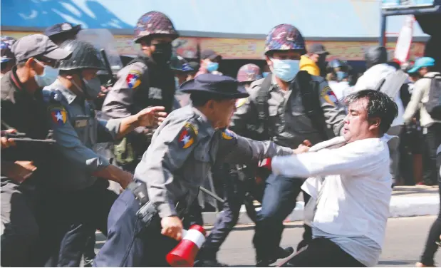  ?? STR/AFP VIA GETTY IMAGES ?? Myanmar police arrest a protester on Friday at a demonstrat­ion in Mawlamyine, Mon State, against the country’s military coup.