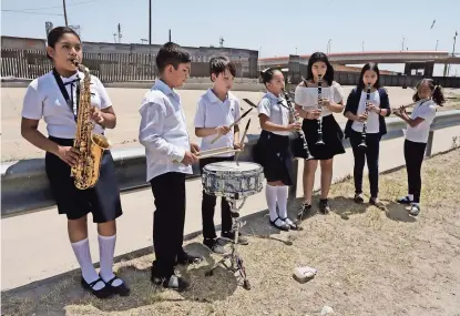  ??  ?? el grupo de músicos toca en los márgenes del cauce que divide a Juárez y el Paso