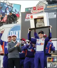  ?? MIKE CAUDILL — THE ASSOCIATED PRESS ?? Denny Hamlin raises the trophy after winning Sunday’s NASCAR Cup Series race at Richmond Raceway.